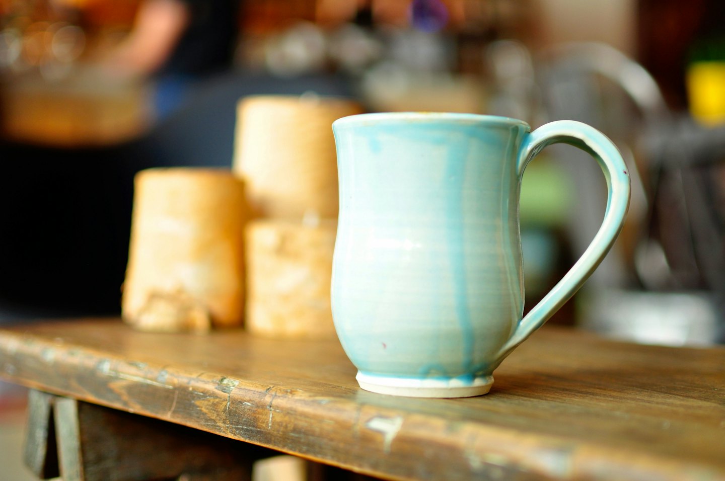A light blue ceramic mug on a distressed wooden table.